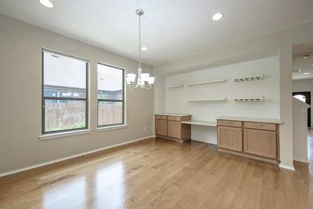 unfurnished dining area with recessed lighting, baseboards, a notable chandelier, and light wood-style floors