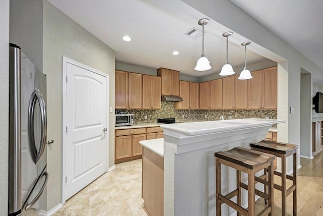 2119 Howell Mountain Dr, Cedar Park, TX 78613 - kitchen featuring stainless steel appliances, under cabinet range hood, backsplash, a kitchen bar, and recessed lighting