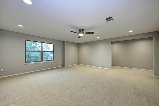 empty room with ceiling fan, light carpet, and baseboards