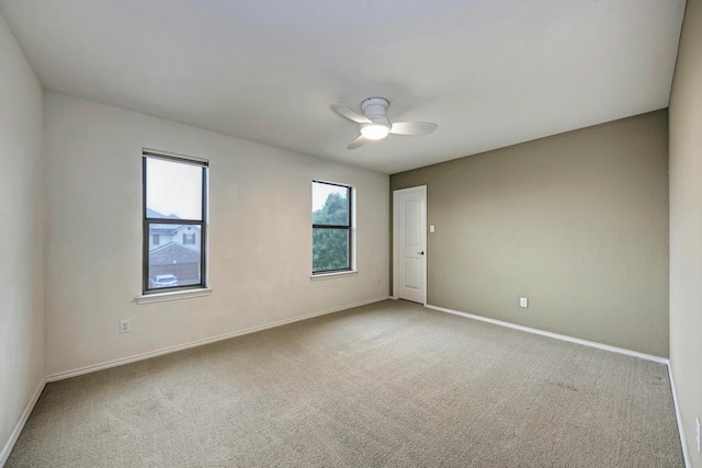 empty room with baseboards, a ceiling fan, and carpet