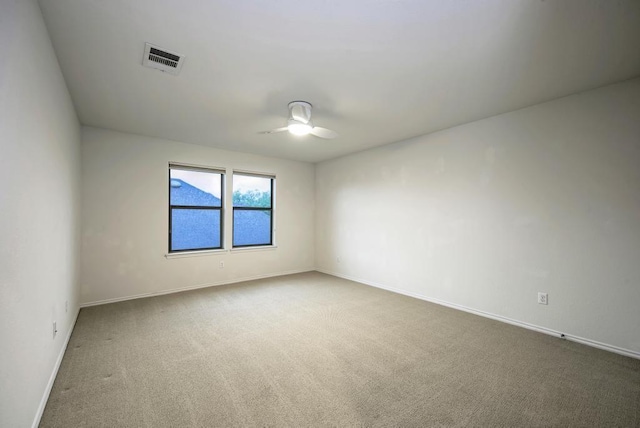 spare room featuring baseboards, ceiling fan, carpet flooring, and visible vents