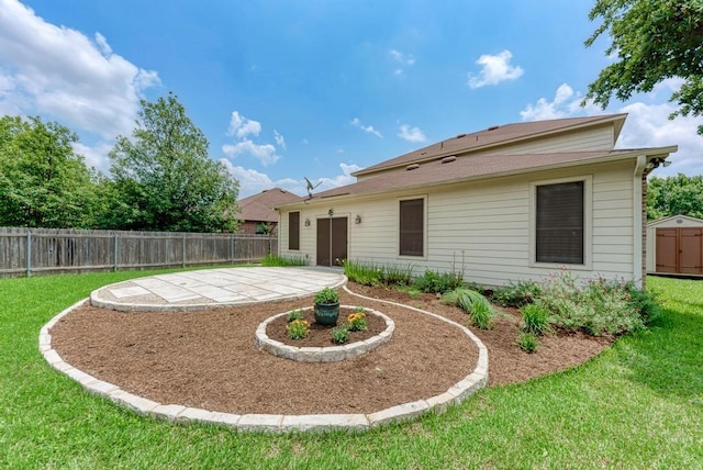 back of property featuring a fenced backyard, an attached garage, a yard, and a patio area