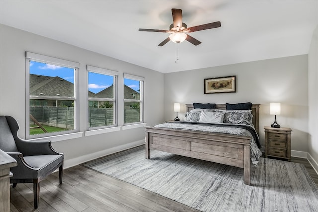 bedroom with baseboards, ceiling fan, and wood finished floors