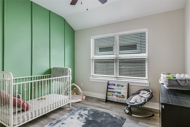 bedroom featuring baseboards, ceiling fan, wood finished floors, and lofted ceiling
