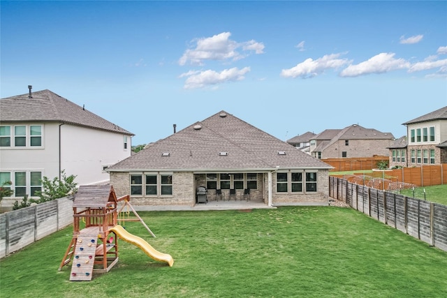 rear view of property with a yard and a fenced backyard