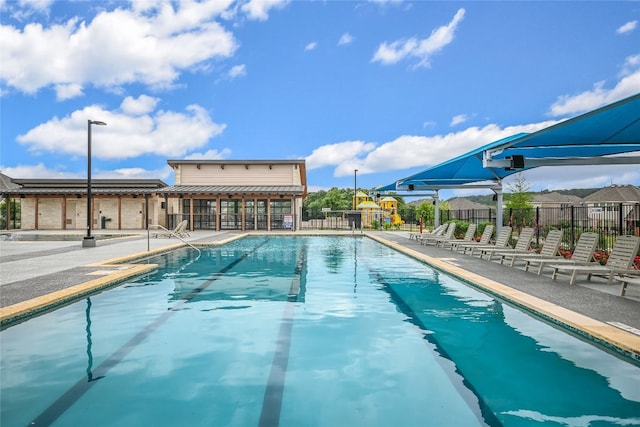 community pool featuring fence and a patio