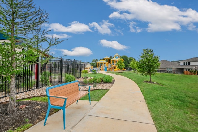 view of home's community with fence, a lawn, and playground community
