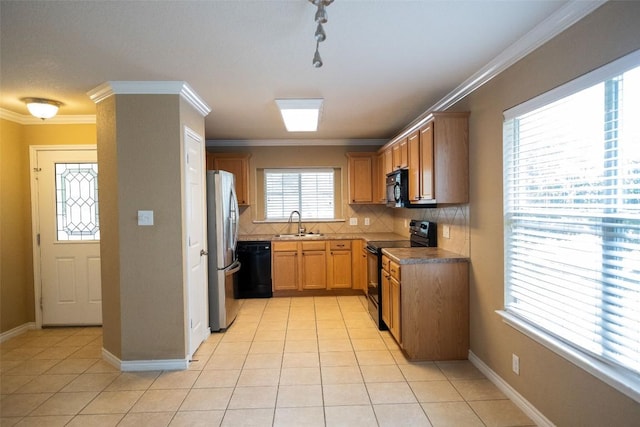 636 Gabriel Mills Dr, Round Rock, TX 78664 - kitchen featuring crown molding, light tile patterned flooring, tasteful backsplash, a sink, and black appliances