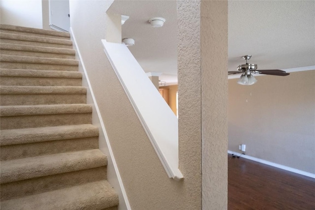 staircase with baseboards, a ceiling fan, and wood finished floors