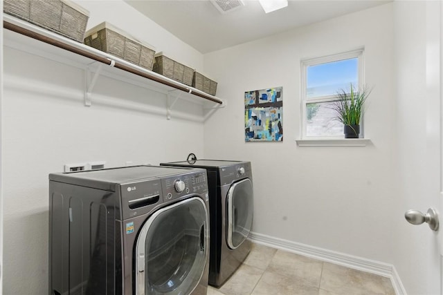 clothes washing area with laundry area, visible vents, light tile patterned flooring, baseboards, and independent washer and dryer