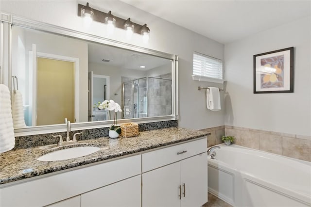 full bathroom featuring vanity, a garden tub, and a shower stall