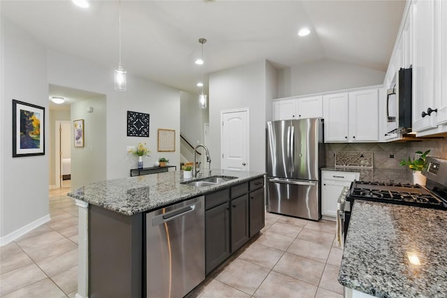 kitchen with a kitchen island with sink, white cabinetry, a sink, backsplash, and stainless steel appliances