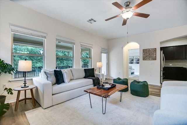 living area with visible vents, plenty of natural light, and wood finished floors