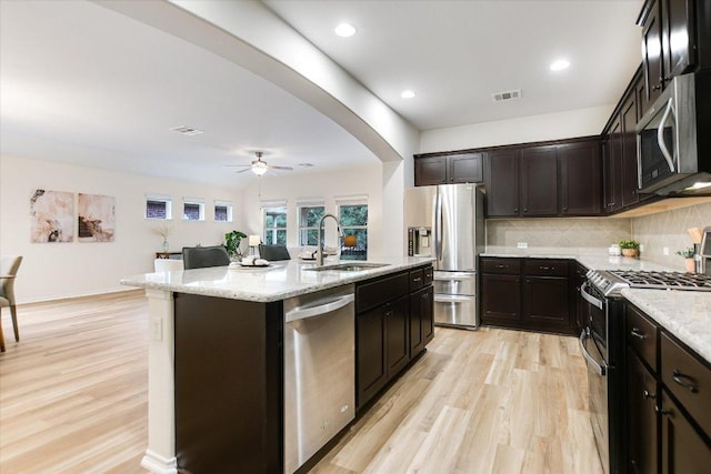 kitchen with a sink, appliances with stainless steel finishes, light wood-style floors, and visible vents