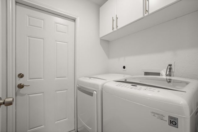 clothes washing area with cabinet space and washing machine and clothes dryer
