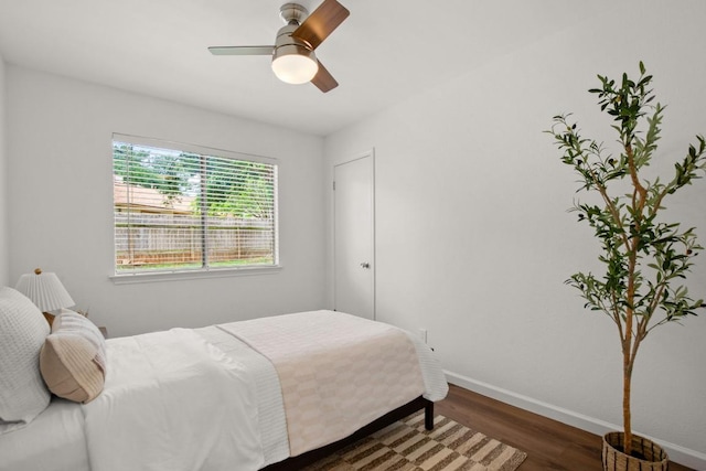bedroom featuring baseboards, a ceiling fan, and wood finished floors