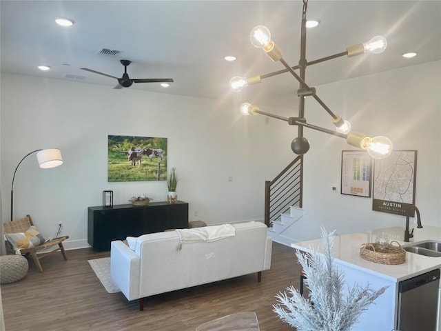 living room featuring dark wood-type flooring, stairs, ceiling fan, and visible vents