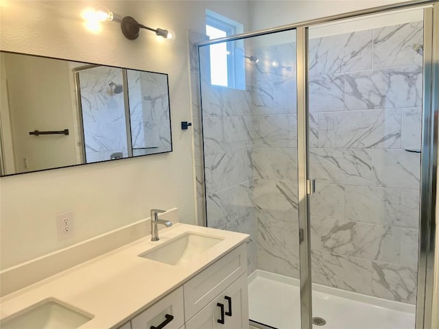 full bath featuring double vanity, a shower stall, and a sink