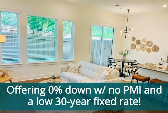 1811 Webberville Rd Unit 2101, Austin, TX 78721 - living room featuring baseboards, wood finished floors, and a chandelier