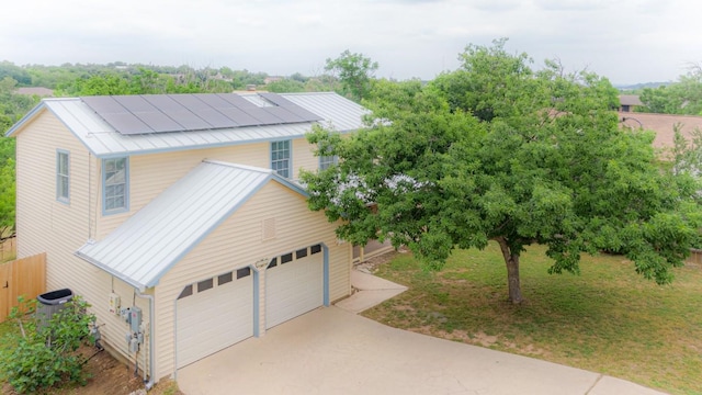 view of front facade with a standing seam roof, a detached garage, and metal roof