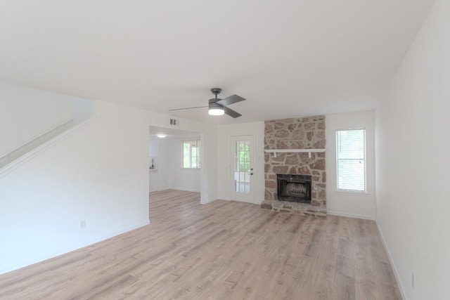 unfurnished living room with baseboards, light wood-style flooring, ceiling fan, and a healthy amount of sunlight