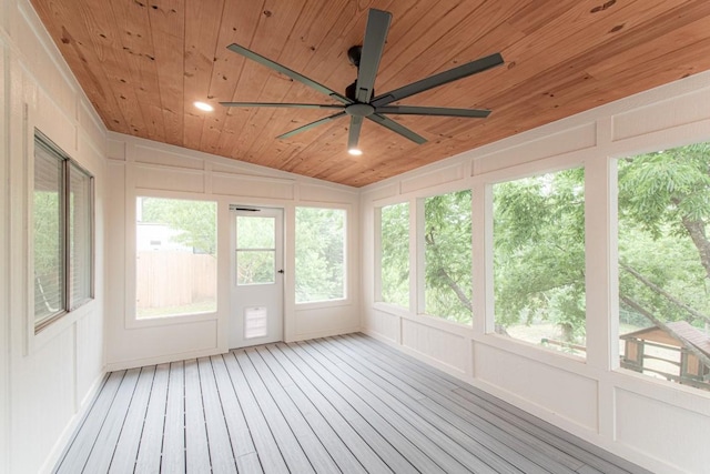unfurnished sunroom featuring wood ceiling, a ceiling fan, a decorative wall, and lofted ceiling