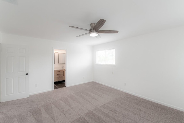 unfurnished bedroom featuring carpet floors, baseboards, ceiling fan, and connected bathroom