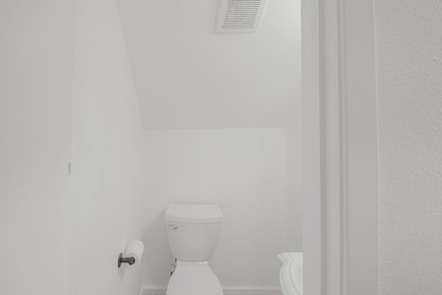 bathroom featuring visible vents, baseboards, and toilet