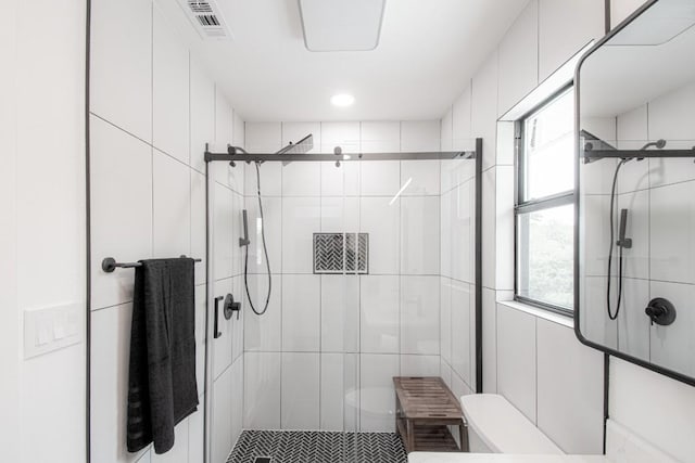 full bathroom featuring toilet, visible vents, and a stall shower