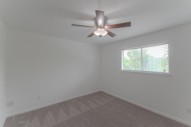 spare room featuring carpet floors, baseboards, and ceiling fan