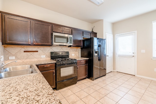 kitchen with dark brown cabinets, light tile patterned flooring, a sink, decorative backsplash, and black appliances