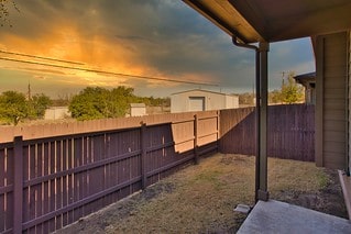 yard at dusk with a fenced backyard