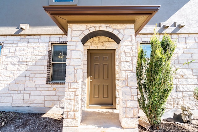 property entrance with stone siding
