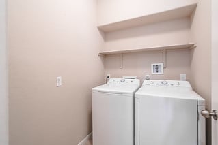 washroom with baseboards, laundry area, and washer and dryer