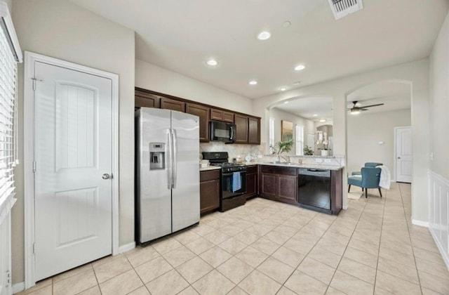 kitchen featuring dark brown cabinets, arched walkways, a ceiling fan, visible vents, and black appliances
