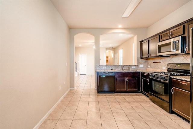 2880UNIT3401 Donnell Dr Unit 3401, Round Rock, TX 78664 - kitchen with black appliances, arched walkways, decorative backsplash, dark brown cabinets, and light stone counters