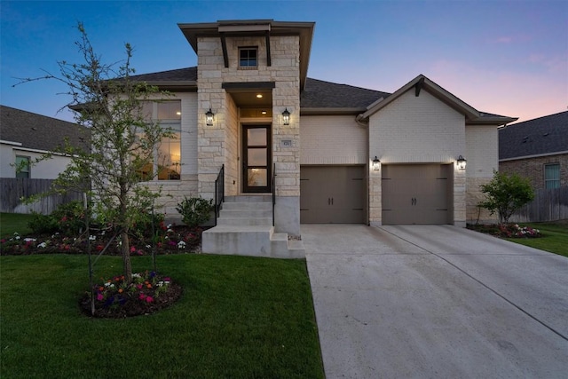 view of front of home featuring concrete driveway, a lawn, fence, and stone siding