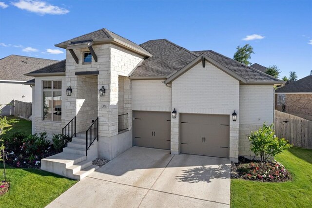 171 William Clayton Dr, Buda, TX 78610 - french country home with concrete driveway, stone siding, and a shingled roof
