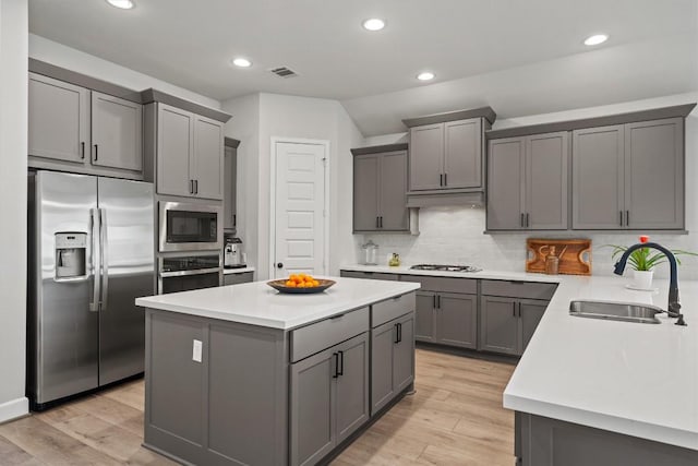 kitchen with gray cabinets, appliances with stainless steel finishes, a sink, and visible vents