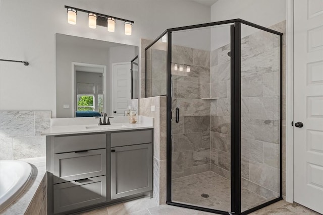 full bathroom featuring vanity, a garden tub, and a stall shower