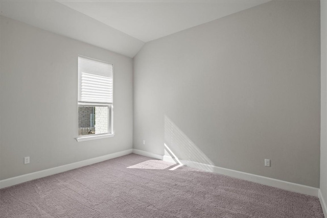 unfurnished room with carpet flooring, baseboards, and vaulted ceiling