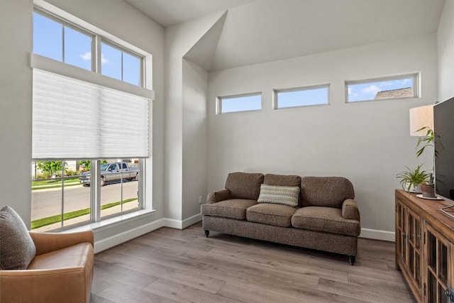 living area featuring baseboards, a healthy amount of sunlight, and light wood finished floors