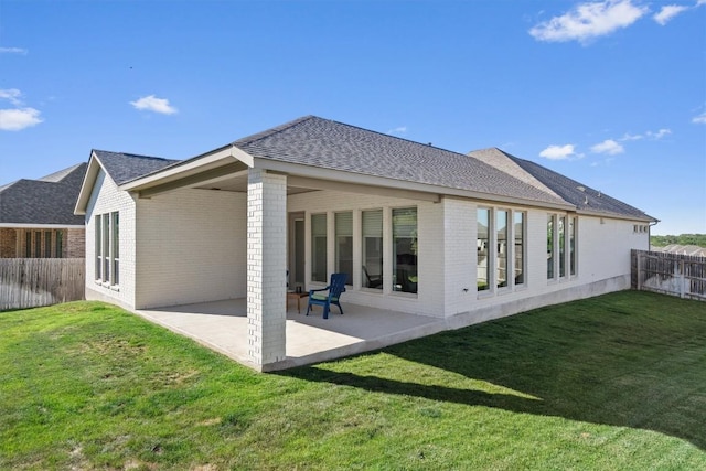back of house with brick siding, a fenced backyard, a patio area, and a shingled roof