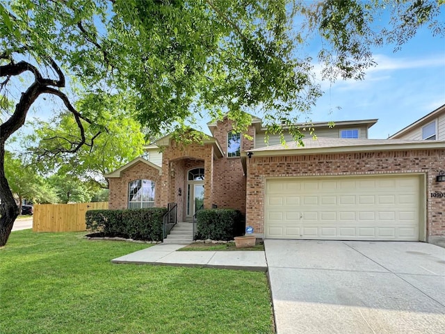 view of front of property with fence, brick siding, a garage, a front yard, and driveway