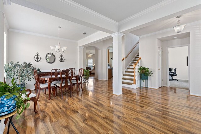 117 Summers Grn, Georgetown, TX 78633 - dining area featuring wood finished floors, stairs, arched walkways, ornate columns, and crown molding