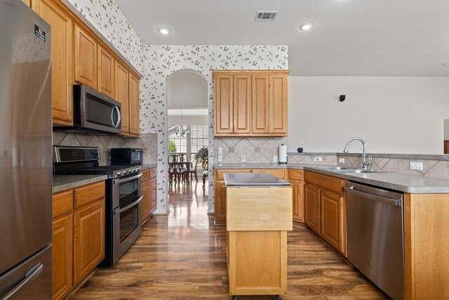 117 Summers Grn, Georgetown, TX 78633 - kitchen with stainless steel appliances, a sink, a kitchen island, dark wood-style flooring, and recessed lighting