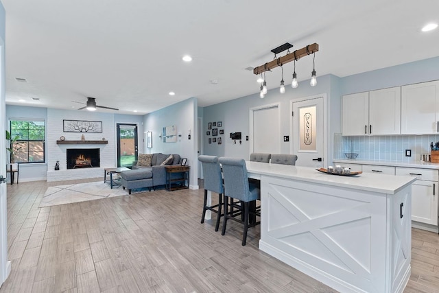 713 Buckingham Pl, Austin, TX 78745 - kitchen with white cabinets, ceiling fan, light countertops, recessed lighting, and a kitchen island