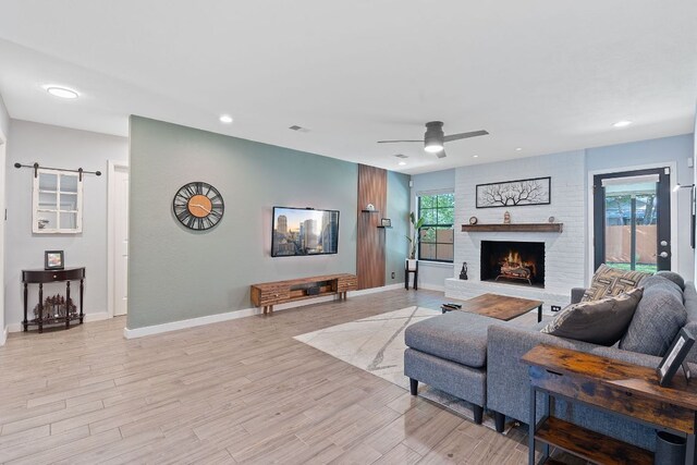 713 Buckingham Pl, Austin, TX 78745 - living room with a ceiling fan, a fireplace, light wood-type flooring, baseboards, and recessed lighting