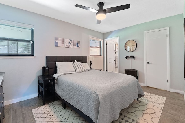 713 Buckingham Pl, Austin, TX 78745 - bedroom with baseboards, multiple windows, a ceiling fan, and light wood finished floors