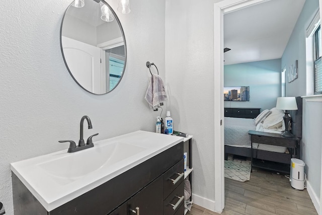 713 Buckingham Pl, Austin, TX 78745 - bathroom with baseboards, a textured wall, wood finished floors, and vanity